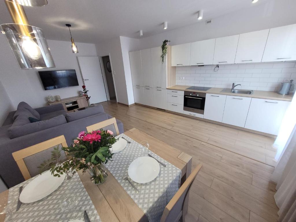 a kitchen and a living room with a table and a couch at Golden Apartament in Szczecin