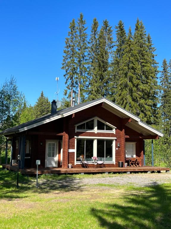 uma cabana de madeira com um grande alpendre na floresta em Holiday Home Amero purnu 1 em Kolinkylä