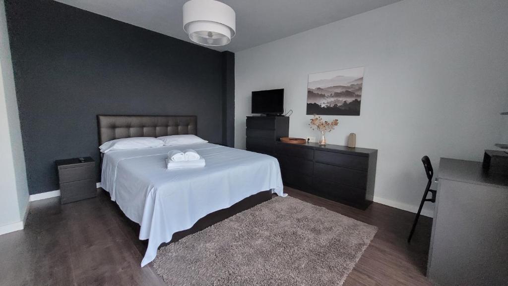 a bedroom with a white bed and a television at Mirador de aguadulce in Aguadulce