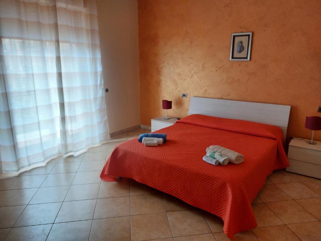シラクーサにあるAppartamento the Architectのベッドルーム1室(赤いベッド1台、タオル付)