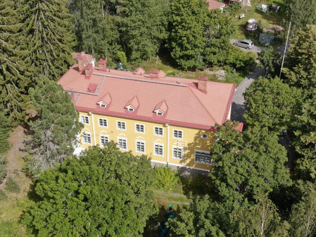 an overhead view of a large yellow house with a red roof at Salonsaaren Pappila in Terälahti
