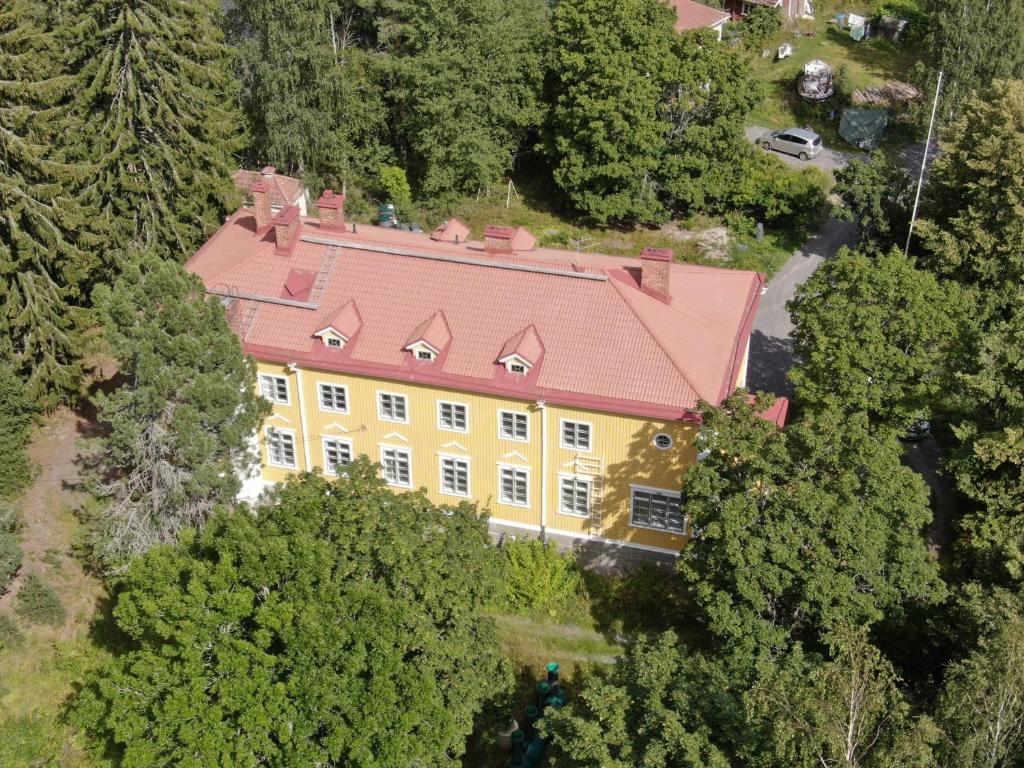 una vista dall'alto di una grande casa gialla con il tetto rosso di Salonsaaren Pappila a Terälahti