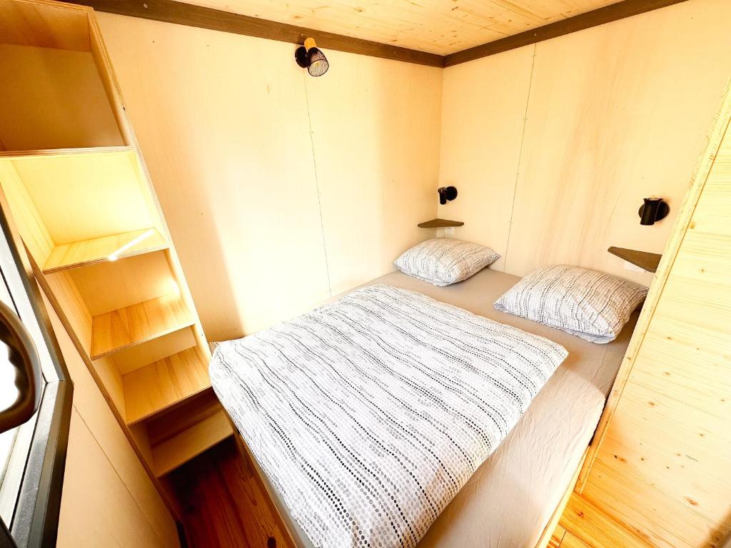 a small room with two beds and shelves in it at tiny house in Cholet