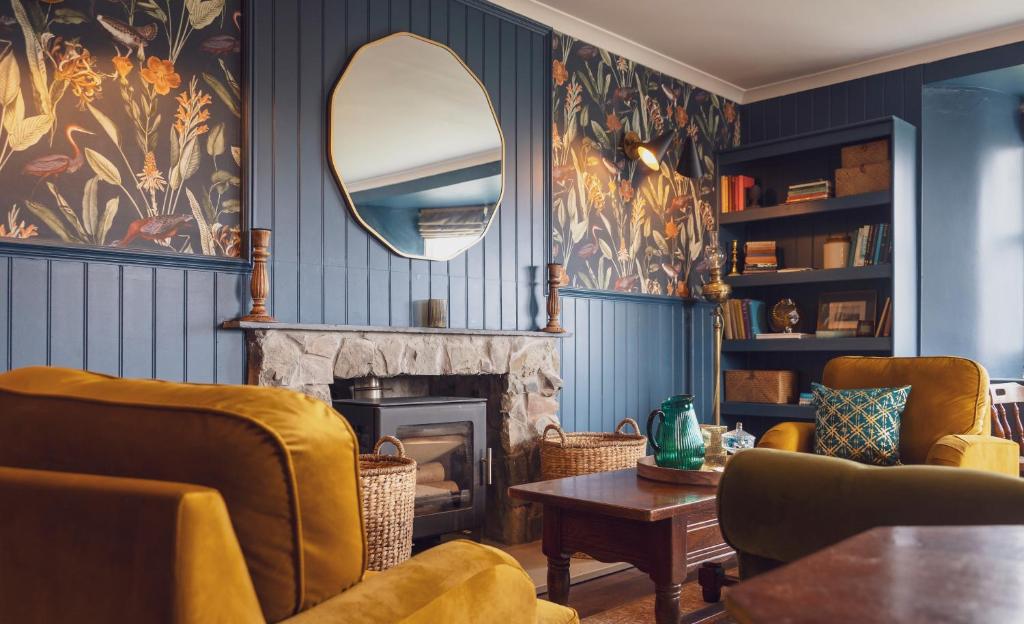 uma sala de estar com lareira e espelho em Ullinish House em Ullinish