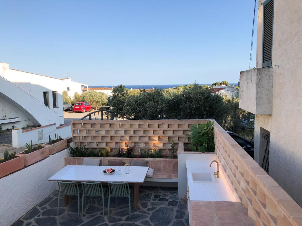 eine Dachterrasse mit einem Tisch und einem Waschbecken in der Unterkunft Can Jove Cadaqués in Cadaqués