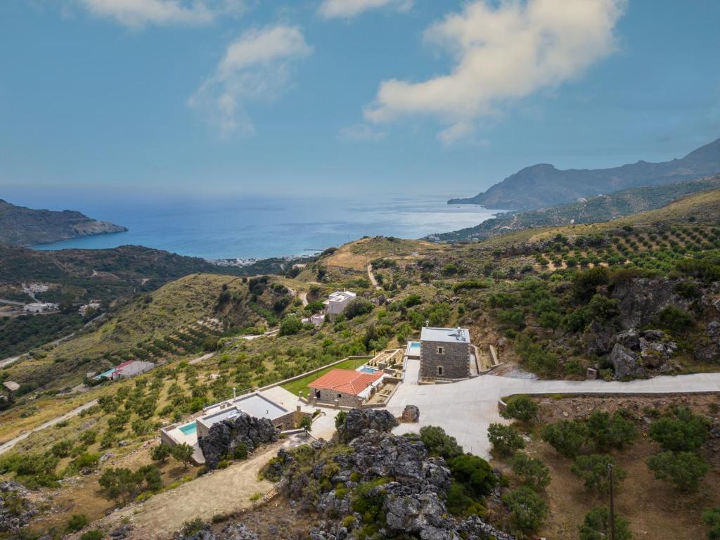 eine Luftansicht eines Hauses auf einem Hügel neben dem Meer in der Unterkunft Nature Villas Myrthios in Plakias