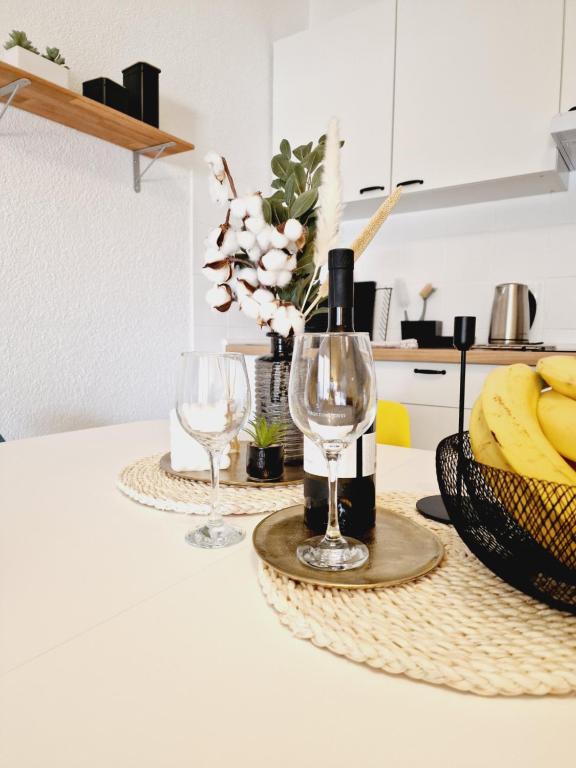 a table with two wine glasses and a basket of bananas at Apartment Melani in Vir