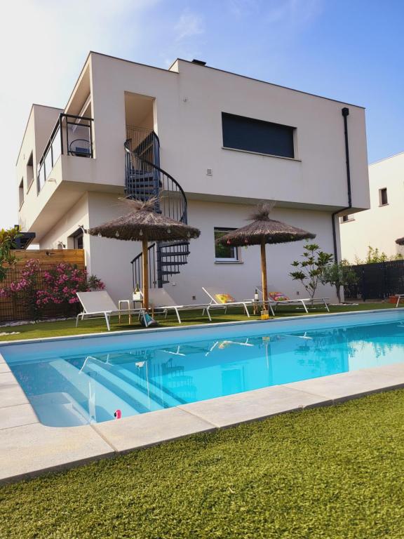 une villa avec piscine devant une maison dans l'établissement Villa les Flamants roses, à Torreilles