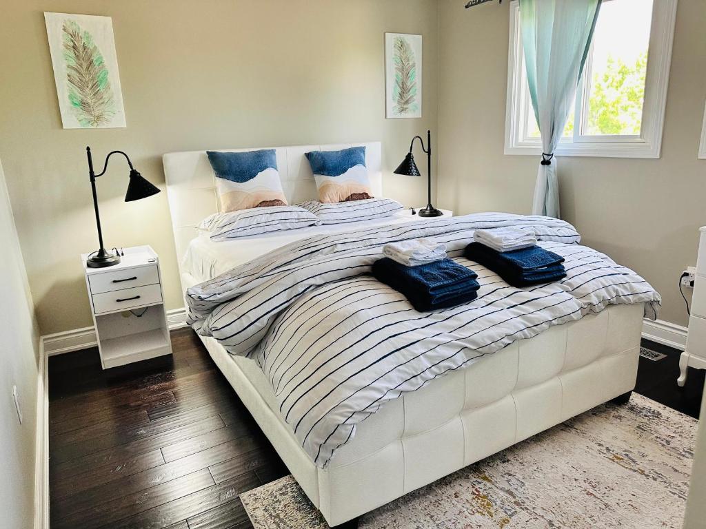 a bedroom with a bed with two blue towels on it at Luxury homestay in Mississauga near square one mall & Pearson Airport in Mississauga
