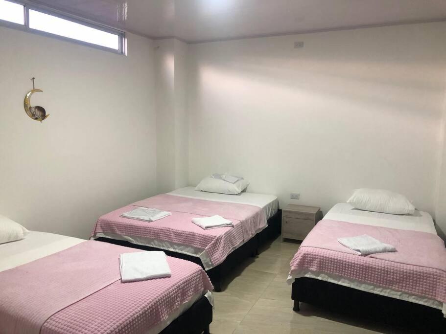 two beds in a room with pink and white sheets at APARTAMENTOS SUPER PENTHOUSE con ZONA BBQ in El Colegio