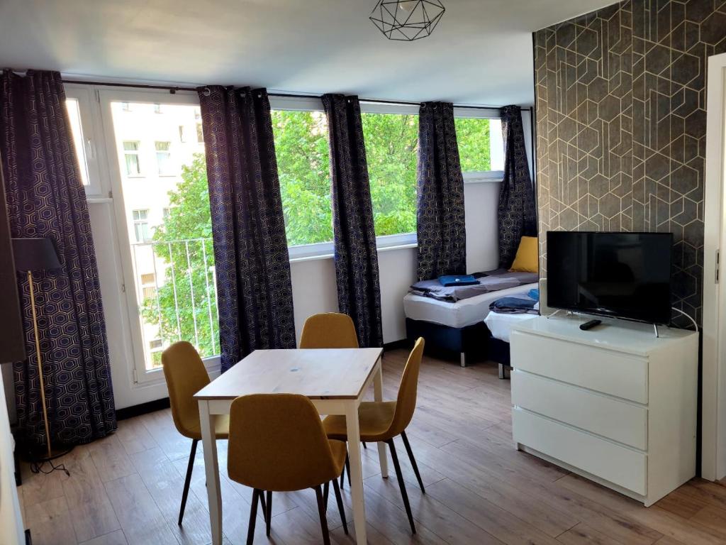 a living room with a dining table and a television at Szczecin Centrum 3 in Szczecin