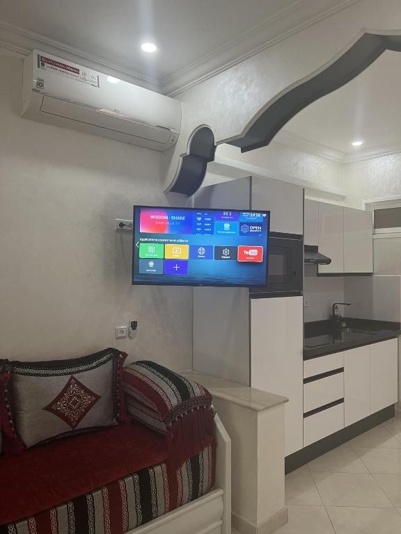 a living room with a flat screen tv on the wall at Rif Appartment in Al Hoceïma