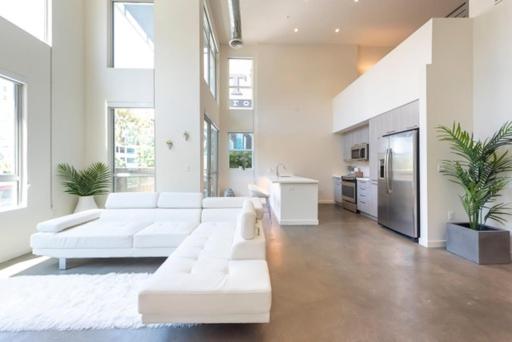 ein Wohnzimmer mit weißen Sofas und eine Küche in der Unterkunft 1500 Sq foot, 3 bed room loft in DTLA (Pool & Hot tub!) in Los Angeles