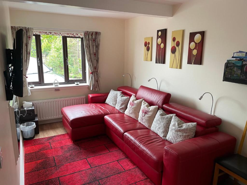 a living room with a red couch and a red rug at The Apartment in Nairn
