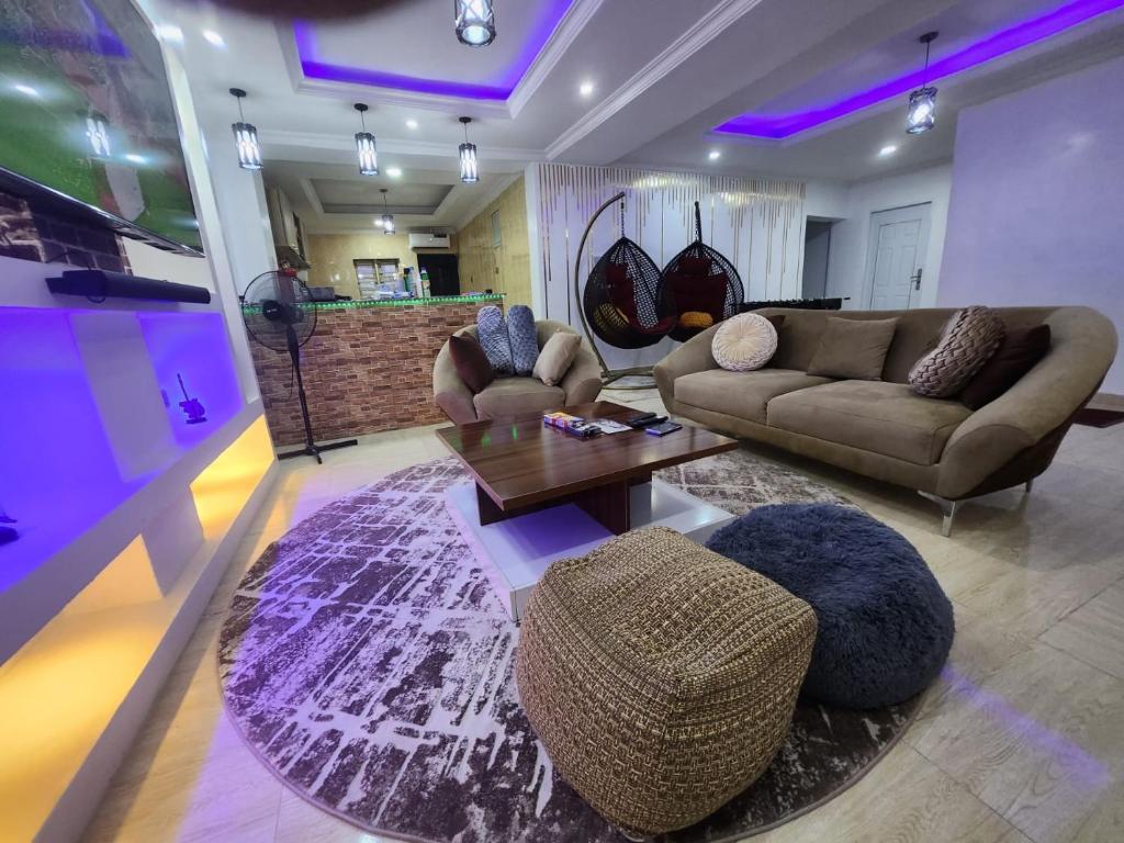 een woonkamer met 2 banken en een tafel bij Exquisite and Cozy 3-bedroom Apt with hot-tub and WiFi in Agege