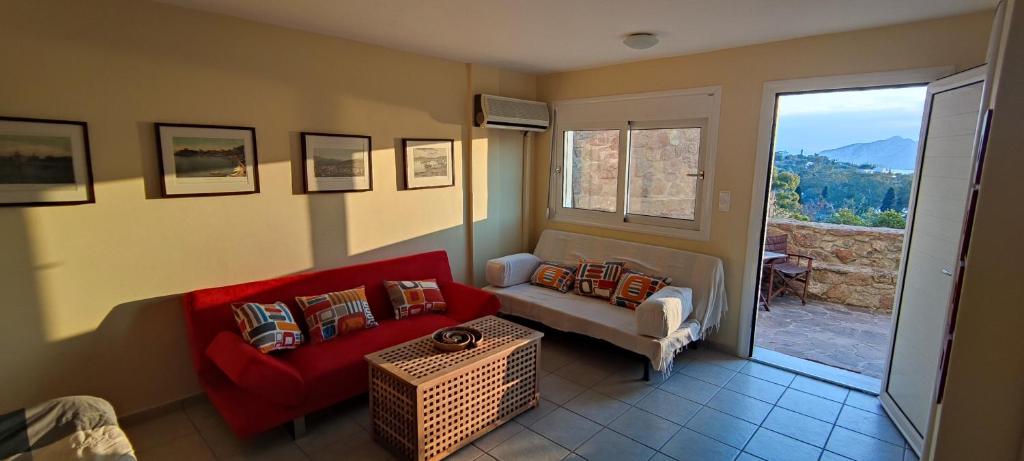 salon z czerwoną kanapą i oknem w obiekcie Buena Vista w mieście Aegenitissa