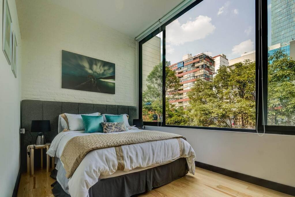 a bedroom with a bed and a large window at Mr. W GREAT MODERN-SUNNY PH LUXE oxford 23 mar in Mexico City