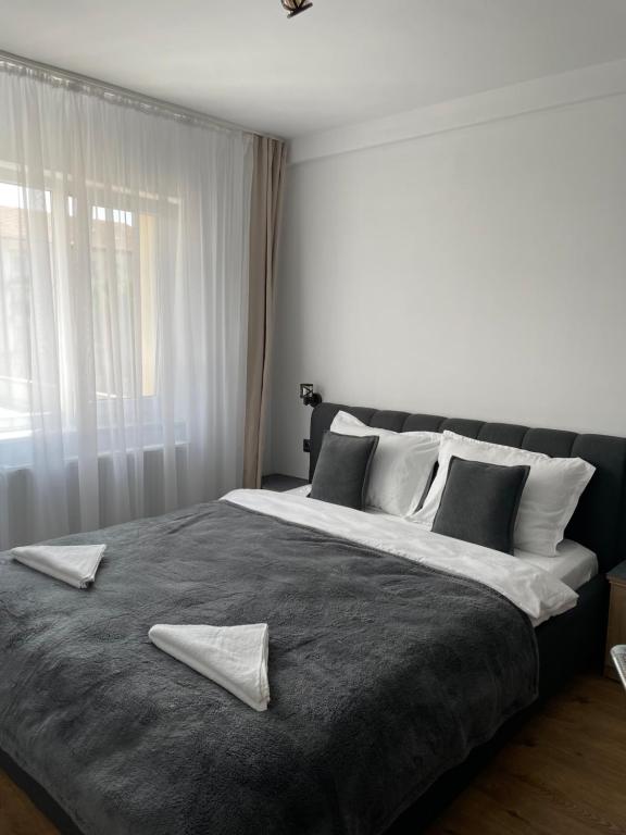 a bedroom with a large bed with two towels on it at Studio Tineretului in Zalău