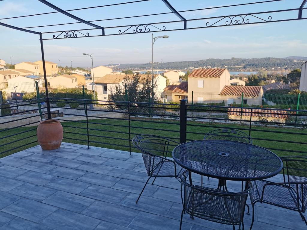 a patio with a table and chairs and a view at Villa moderne sur les hauteurs d'Aramon in Aramon