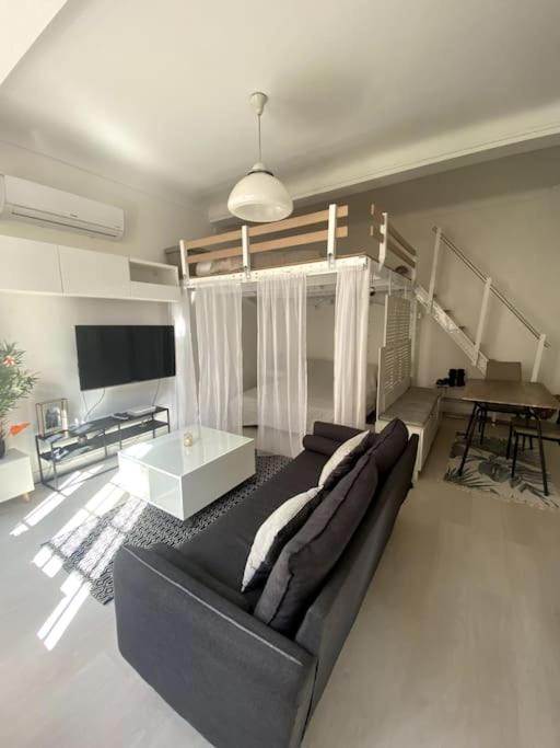 un salon avec un canapé noir et une table dans l'établissement Moderne, terrasse et climatisé, Proche plage, spacieux, à Antibes