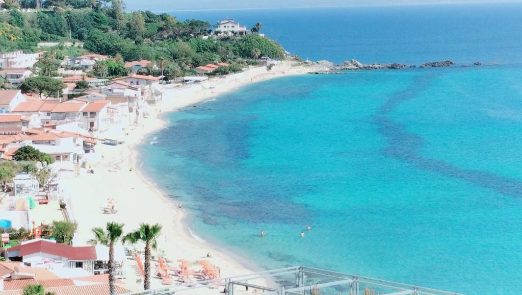 eine Luftblick auf einen Strand mit Palmen und das Meer in der Unterkunft Dimore Acquasale- Sea View Houses in Capo Vaticano