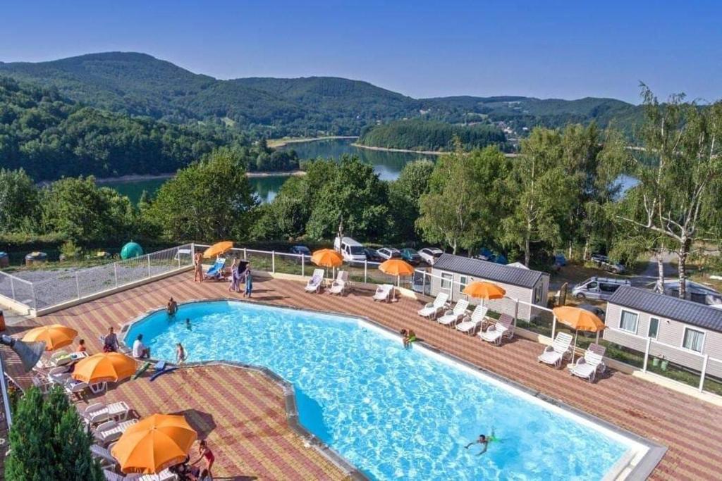 a large swimming pool with umbrellas and chairs at mobilhome 5 couchages in Nages