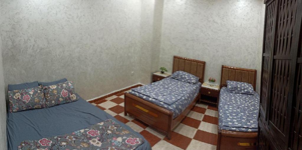 um quarto com 2 camas individuais e uma secretária em residhome em Sétif