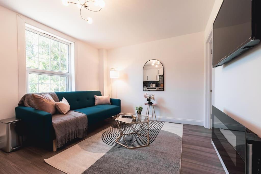 a living room with a blue couch and a mirror at Barite - 1 Bedroom Flat in Reading