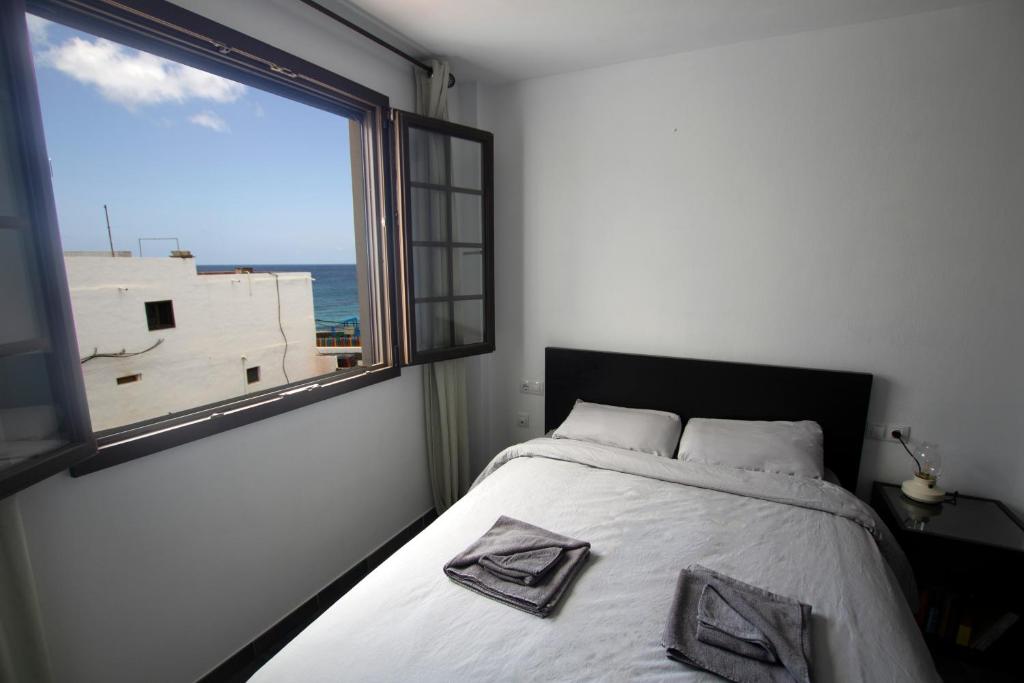 アリエタにあるLa Casa del Atlánticoのベッドルーム1室(ベッド1台、大きな窓付)