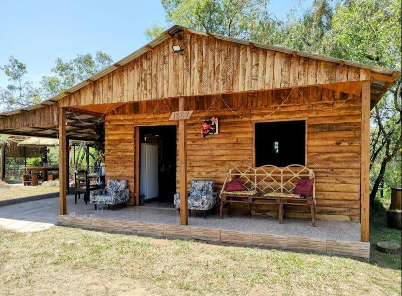 una cabina in legno con 2 sedie e una panca di Sítio pousada e Refúgio lazer e eventos a Santana do Livramento
