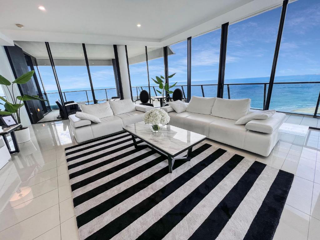 un soggiorno con un divano bianco e un tavolo di Sub Penthouse Oracle 46th floor - GC Getaways a Gold Coast