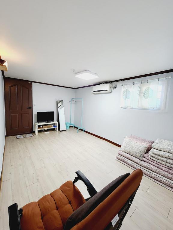 una sala de estar con sofá y una habitación con TV en Yeobyeol Guesthouse, en Jeonju