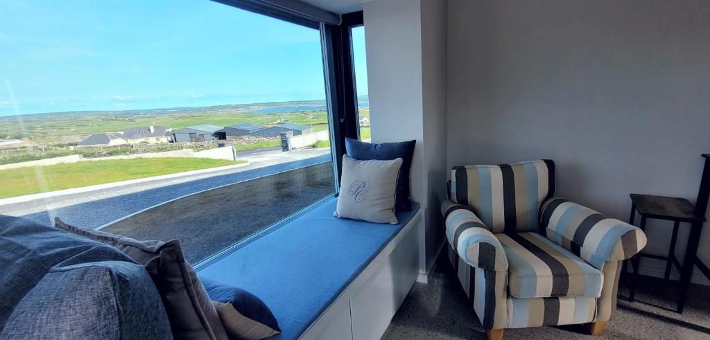 a window seat with a chair and a window with a view at Moher Lodge in Liscannor
