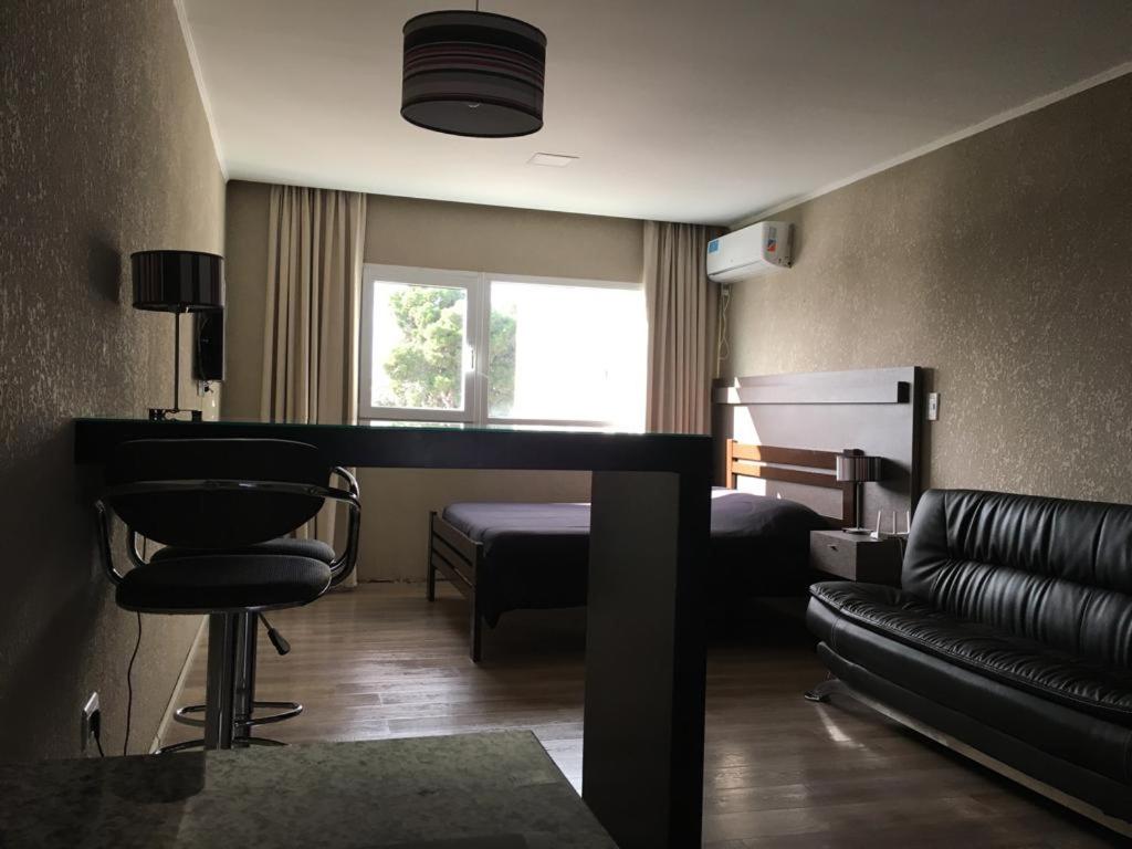 Habitación de hotel con sofá y cama en Departamentos Casa del Parque en Necochea