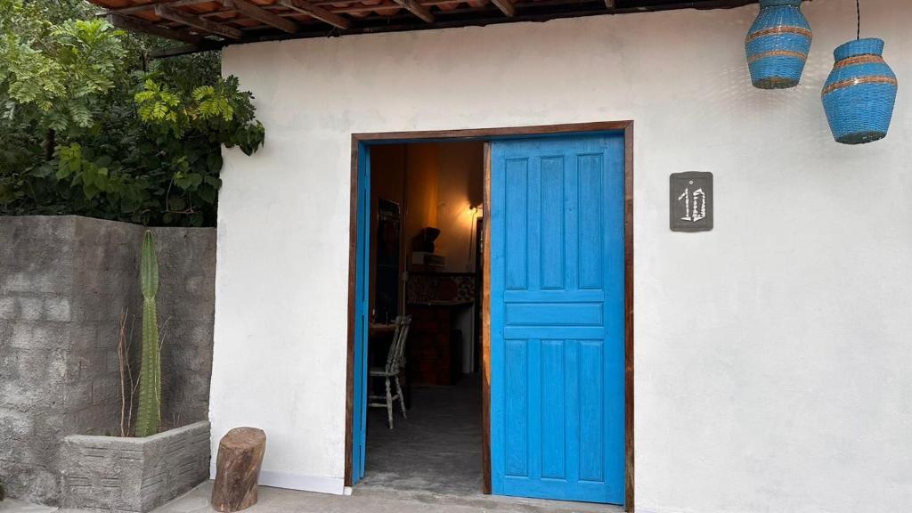 a blue door to a white house with a table at Amorada in Santo Amaro