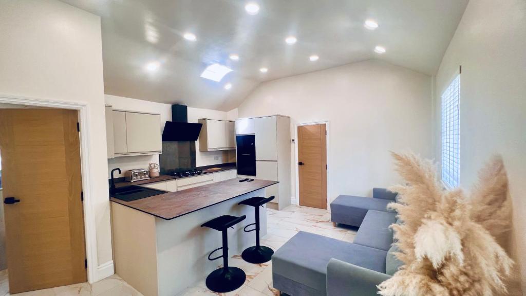 eine Küche und ein Wohnzimmer mit einem blauen Sofa und einer Theke in der Unterkunft Cozy Charming Bungalow BRAND NEW in Preston