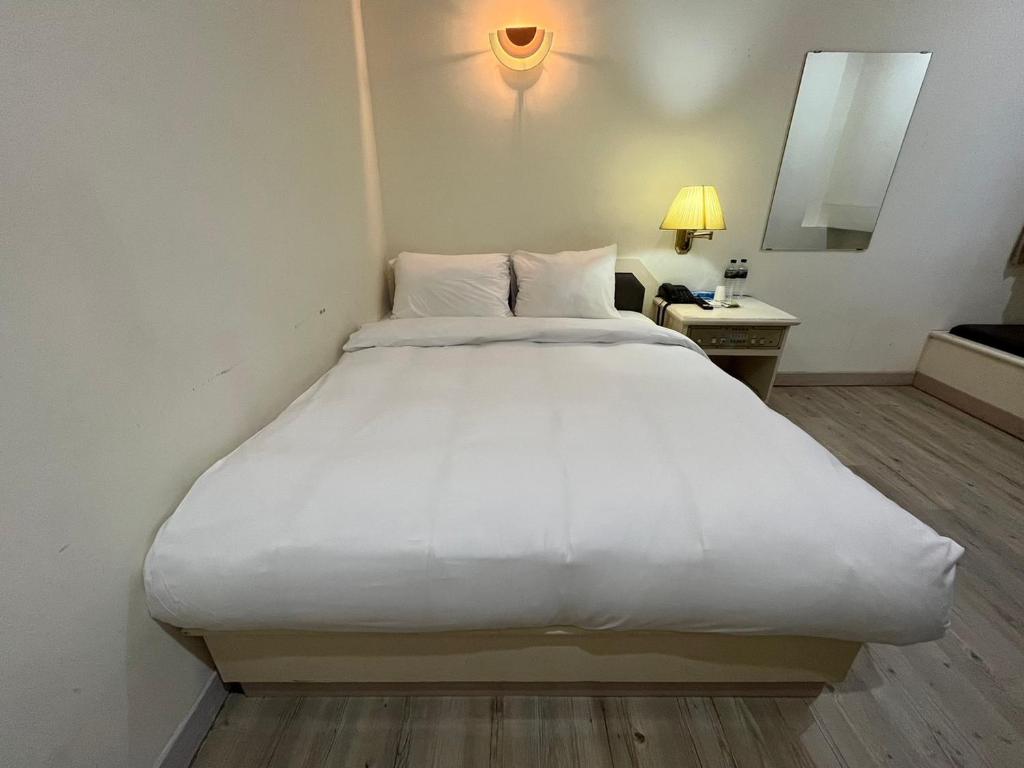 un grande letto bianco in una stanza d'albergo di 日日 Meworld a Beigang