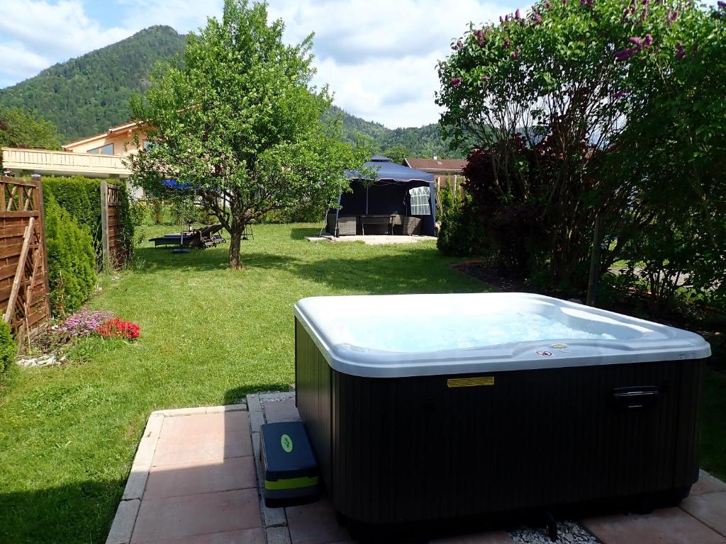 a hot tub sitting on a patio in a yard at Chiemgauferienwohnungen - Wanderlust und Alpenrose in Unterwössen