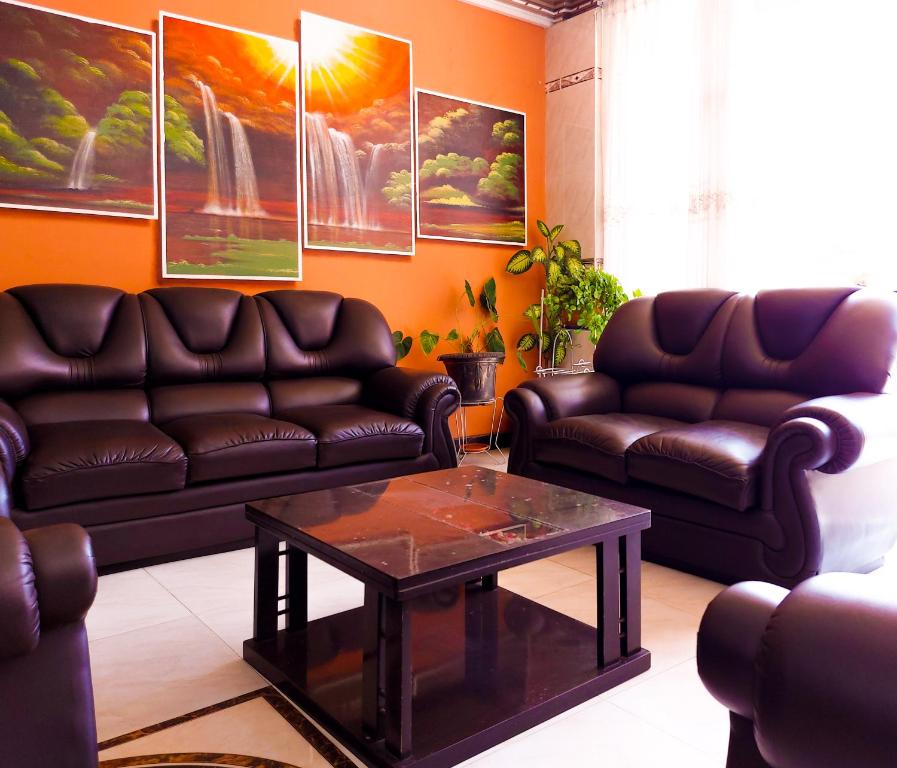 a living room with two leather couches and a coffee table at Hotel El Super 8 in Cochabamba