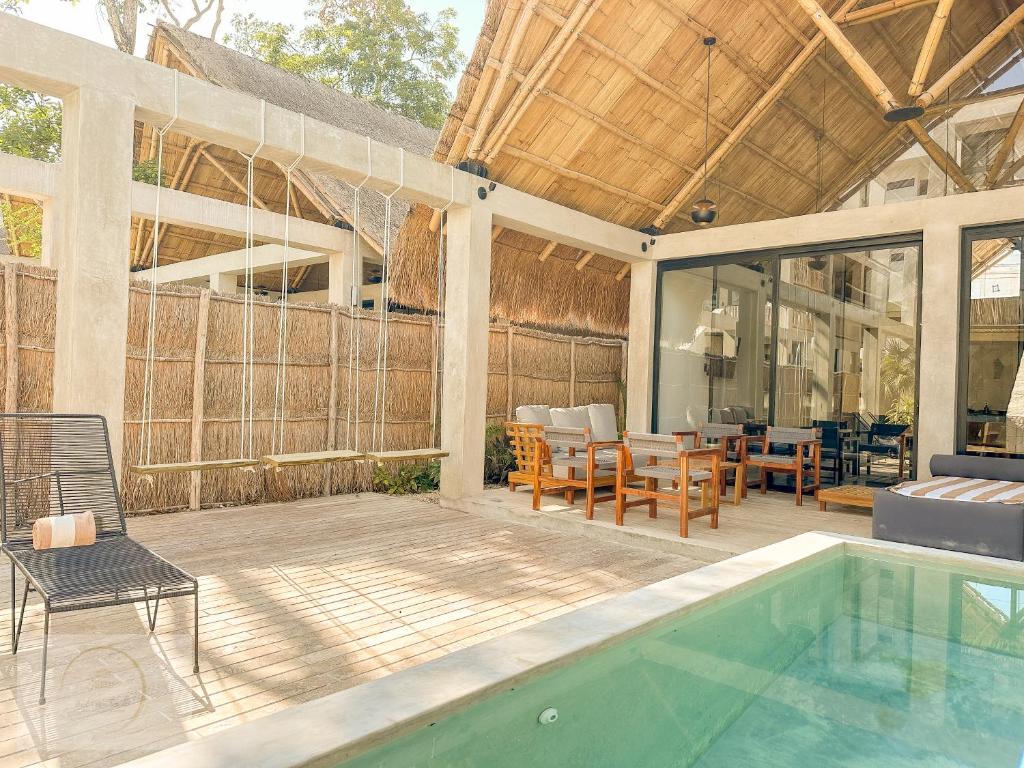 un patio extérieur avec une piscine et un coin repas dans l'établissement Villa Toh, à Tulum