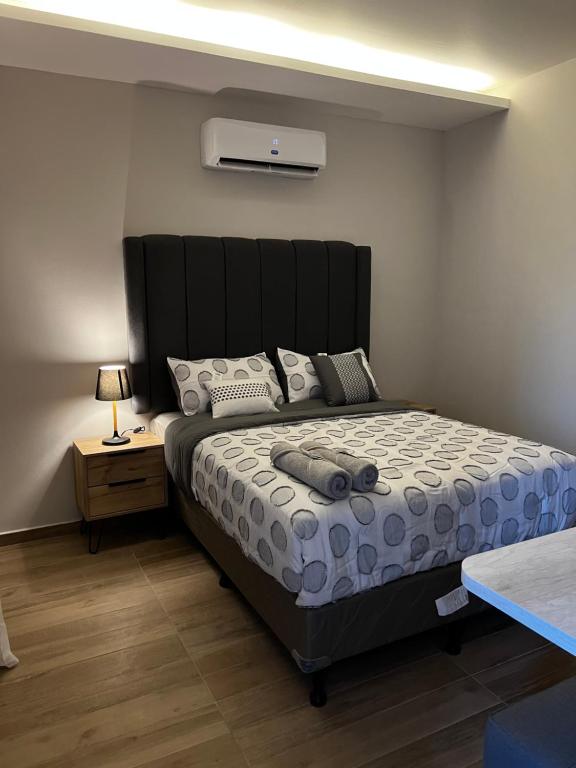 a bedroom with a large bed with a black headboard at Habitación Cerezo en Palmerola, Comayagua in Comayagua