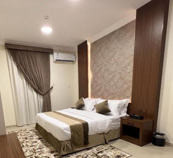 a hotel room with a bed and a window at سمو سويت للشقق المخدومة 2 Smo Suites in Riyadh