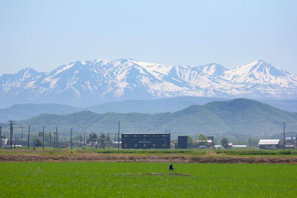 a person in a field with mountains in the background at Yadoya YADOKARI 2nd in Pippu