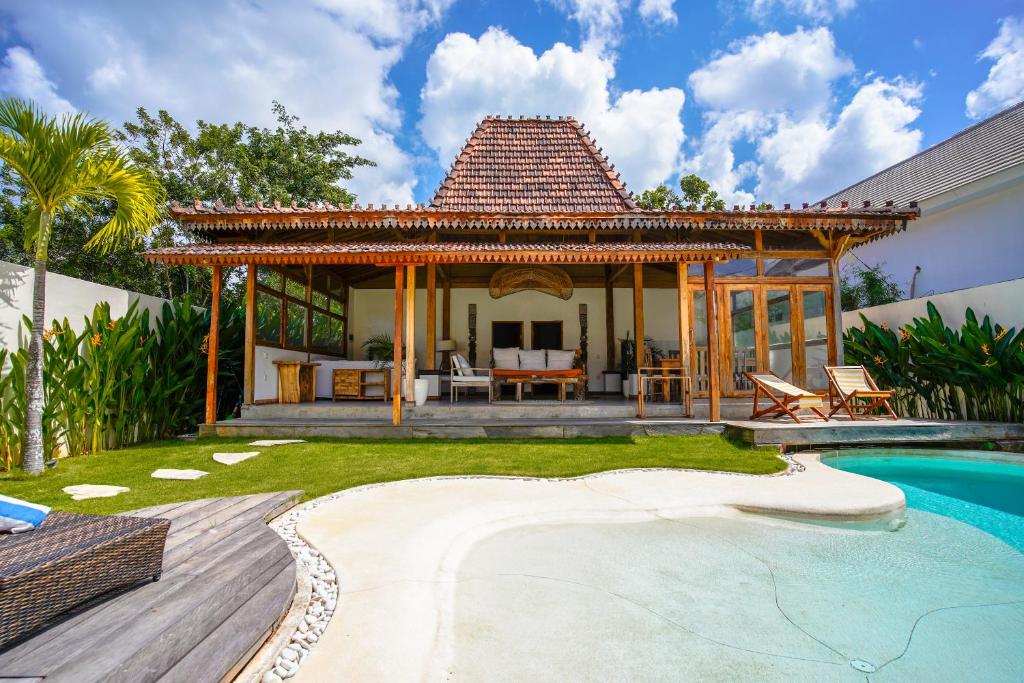 a villa with a swimming pool and a house at Villa Miti Bingin in Uluwatu