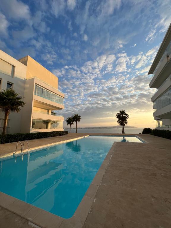 une piscine en face d'un bâtiment dans l'établissement Cap Tingis, à Tanger