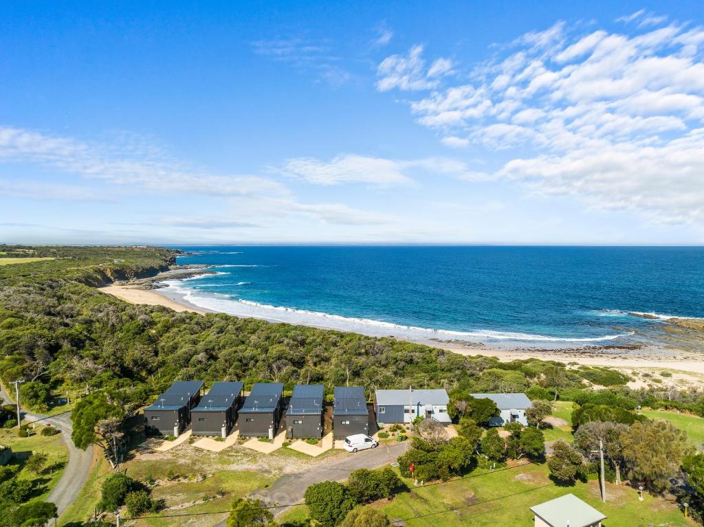 - une vue aérienne sur une plage avec des maisons et l'océan dans l'établissement Ingenia Holidays Cape Paterson, à Cape Paterson