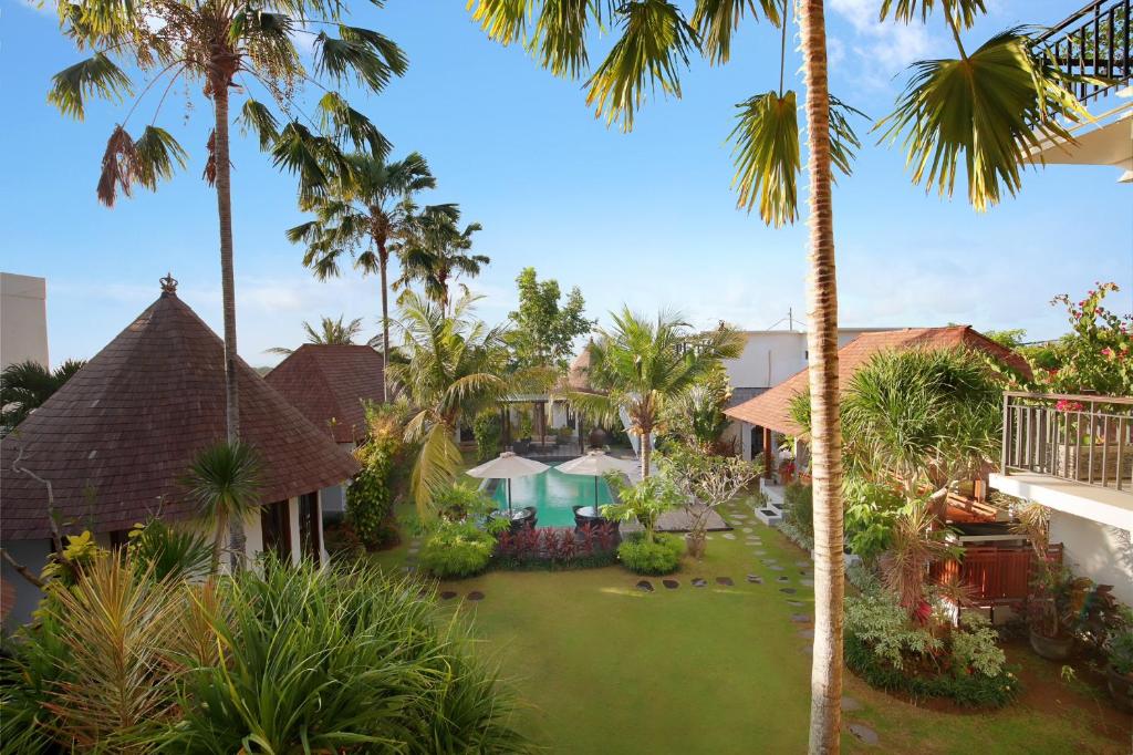 una vista aerea su un cortile del resort con palme di Kandahill Bali a Uluwatu