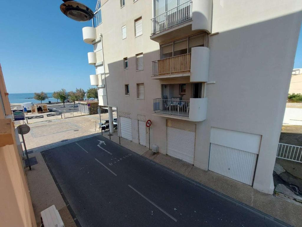 Une rue vide à côté d'un grand bâtiment dans l'établissement Grau d'Agde: Appt 2P rénové à 20m de la plage - FR-1-423-282, au Grau-dʼAgde
