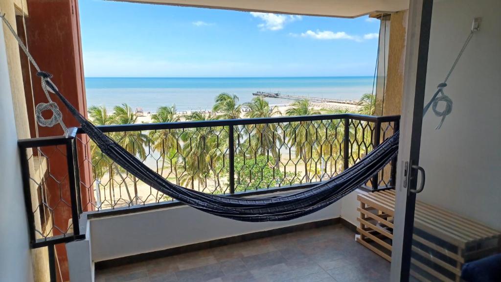 un balcón con hamaca y vistas a la playa en RH03 Riohacha apartamento perfecto para trabajar o vacacionar frente a la playa en Riohacha