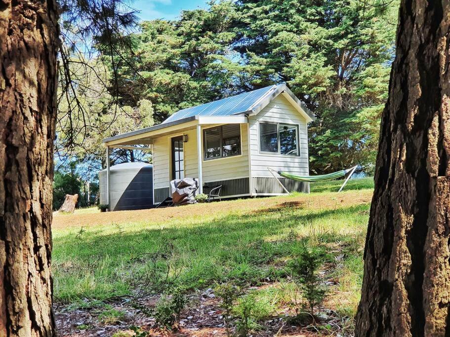 una piccola casa gialla in mezzo a un campo di Mornington Peninsula Tiny House - Tiny Stays a Red Hill